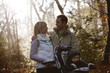 A young couple pushing a stroller in the park, smiling