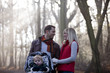 A young couple pushing a stroller in the park, smiling