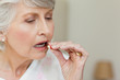 Sick senior woman taking her pills