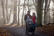 A young couple pushing a stroller in the park, laughing