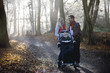 A young couple pushing a stroller in the park