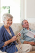 Woman knitting while her husband is sleeping Woman knitting while her husband is sleeping