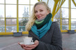 The young white girl has control over a cup with tea and smiles