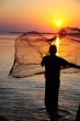 throwing fishing net during sunset throwing fishing net during sunset