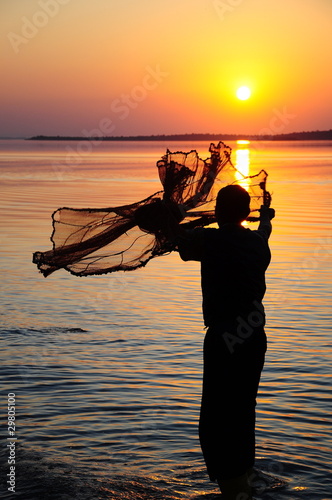 Foto: throwing fishing net during sunset throwing fishing net during sunset