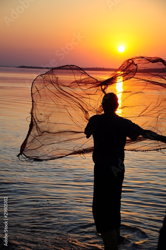 Foto: throwing fishing net during sunset throwing fishing net during sunset