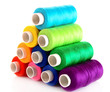 Pyramid of many-coloured bobbins of thread isolated on white