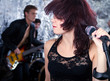 Beautiful rock singer with her band in the background