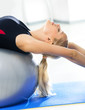 Image : Young woman in sportswear working out with fit ball