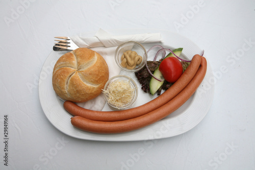 Photo: Vienna sausages with bread and salad on a white background Vienna sausages with bread and salad on a white background