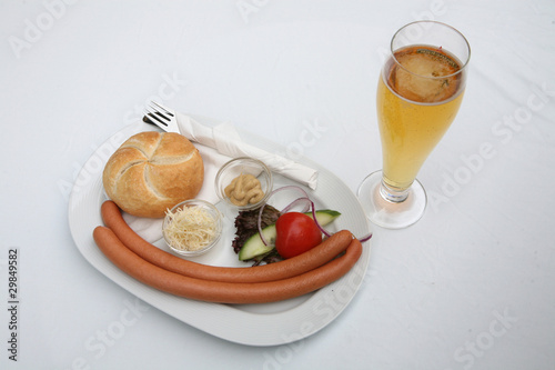 Photo: Vienna sausages with bread, salad and beer on a white background Vienna sausages with bread, salad and beer on a white background