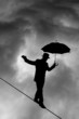 Tightrope Silhouette against black cloud