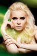Luxury blond woman model with big ring in magic green mist