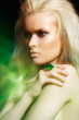 Luxury blond woman model with big ring in magic green mist