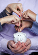 Hands inserting money in the piggybank Hands inserting money in the piggybank