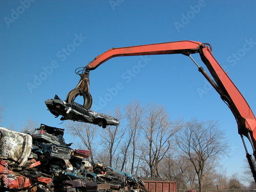Photo: junkyard crane and claw with crushed car junkyard crane and claw with crushed car