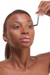 Photo: Black woman applying mascara on her eyelashes Black woman applying mascara on her eyelashes