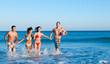Foto: Smiling friends playing at beach Smiling friends playing at beach