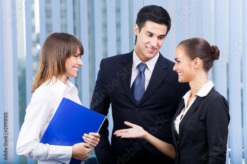 Photo: Three young happy businesspeople at office Three young happy businesspeople at office