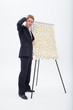 Confused businessman standing at flipchart with abundance of post-its