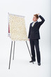 Confused businessman standing at flipchart with abundance of post-its
