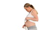 Pregnant blond woman playing with the shoes of her future baby