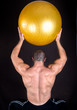 Perfect muscular man with yellow ball posing artistic