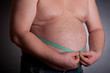 Fat man holding a measurement tape