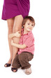 Little boy hugging the leg of his mum