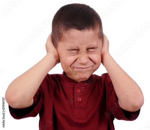 Photo: kid covering ears from loud noise, isolated kid covering ears from loud noise, isolated