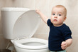 Details der Fotografie ein neugieriger kleiner Junge schaut in die Toilette