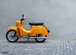 Yellow Motorbike by Grey Concrete Wall