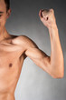 Part of male torso and arm. On gray background