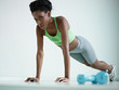 african woman doing series of push-ups in gym
