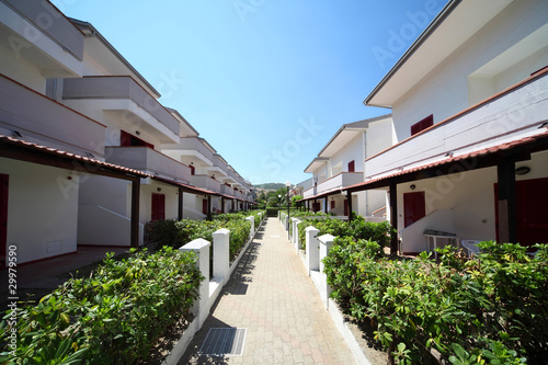 Photo: Little street between two-storeyed white cottages Little street between two-storeyed white cottages