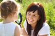 Mother and daughter looking at each other through loupe