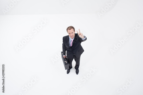 Photo: Businessman with briefcase making Victory sign Businessman with briefcase making Victory sign