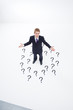 Confused businessman surrounded by question marks