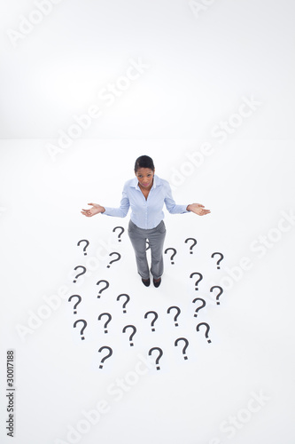 Photo: Confused businesswoman surrounded by question marks Confused businesswoman surrounded by question marks