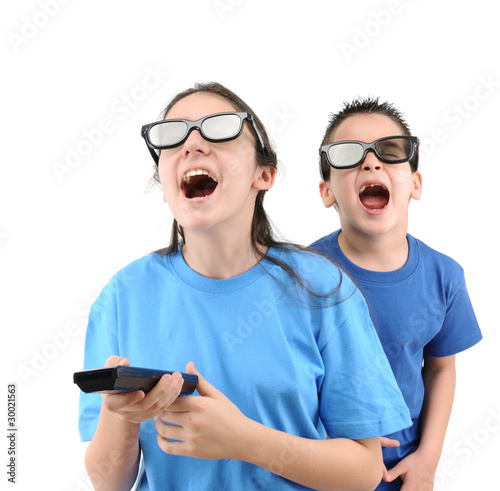 Photo: Brother and sister having fun while watching TV isolated. Brother and sister having fun while watching TV isolated.