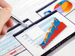 Male hand with pen on the investment charts