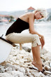 Beautiful blonde girl sitting at the lake