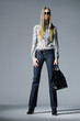 Fashion girl with bag posing in the studio