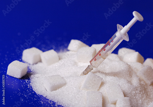 Photo: Insulin injection white a pile of sugar Insulin injection white a pile of sugar