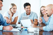 Smiling business people with paper work in board room