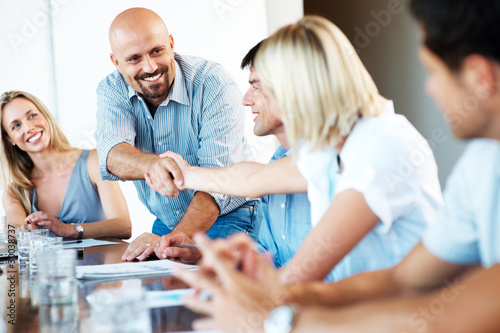 Photo: Happy group of businesspeople working together at a meeting Happy group of businesspeople working together at a meeting