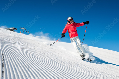 Photo: Woman skiing in high mountains - modified piste Woman skiing in high mountains - modified piste
