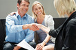 Happy young couple meeting a female financial advisor Happy young couple meeting a female financial advisor