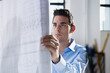 architect reading blueprint in office