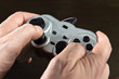 hands holding silver gamepad of video game